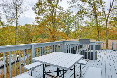 a picnic table on the deck of a house at Luxury Home with Game Room, 4 Mi to Bushkill Falls! in Saw Creek