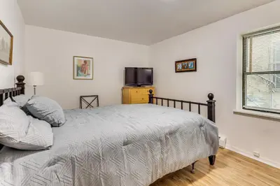 a bedroom with a bed and a tv on the wall at Easy NYC Commute Guttenberg Getaway Near Parks in Guttenberg
