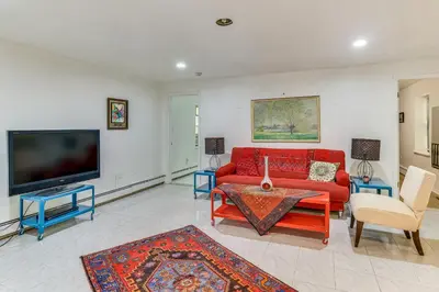 a living room with a red couch and a tv at Easy NYC Commute Guttenberg Getaway Near Parks in Guttenberg
