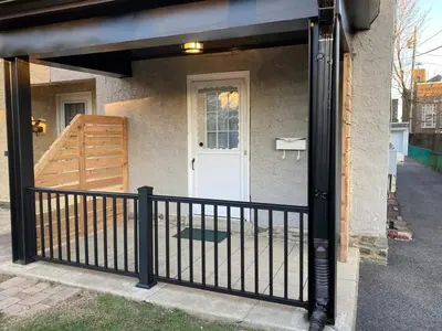a porch with a black fence and a white door at Bryn Mawr Spacious Grnd Floor Apt Free Parking in Bryn Mawr