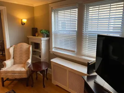 a living room with a television and a chair and a window at Bryn Mawr Spacious Grnd Floor Apt Free Parking in Bryn Mawr
