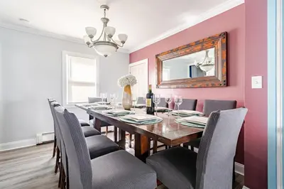 a dining room with a table with chairs and a mirror at Gythio in Keansburg