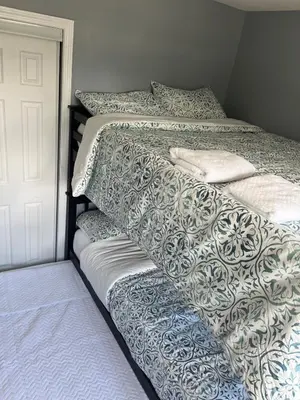 a bedroom with a bed with a white and blue comforter at Gythio in Keansburg
