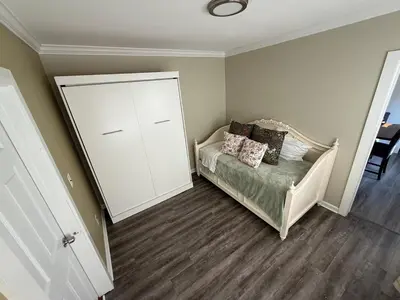 a small bedroom with a bed and a white cabinet at Gythio in Keansburg