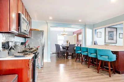 a kitchen with blue chairs and a dining room at Gythio in Keansburg
