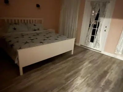 a bedroom with a white bed and a window at Odessa in Keansburg