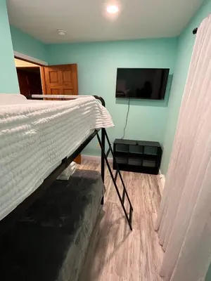 a bedroom with a bed and a flat screen tv at Odessa in Keansburg