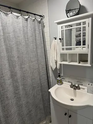 a bathroom with a shower curtain and a sink at Modern Stay in Downtown Jersey City, Close to NYC! in Jersey City