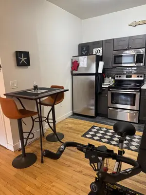 a kitchen with a table and a kitchen with a refrigerator at Modern Stay in Downtown Jersey City, Close to NYC! in Jersey City