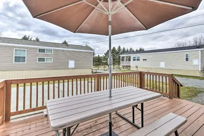 a wooden deck with a bench and an umbrella at Triple Suites Close to Skiing in Pleasant Mount