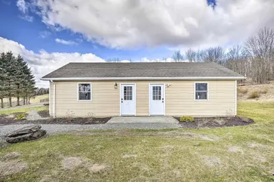 a small yellow house in a field at Romantic Escape Cottage and Suites Close to Ski Trails in Pleasant Mount