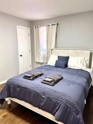 a bedroom with a large bed with two pillows on it at Peaceful 3BR House w Easy NYC Access in South River, NJ in South River