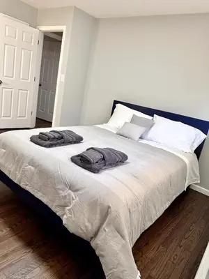 a bedroom with a large bed with two towels on it at Peaceful 3BR House w Easy NYC Access in South River, NJ in South River