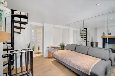 a living room with a couch and a spiral staircase at The Twisty Nest on 17th in Philadelphia