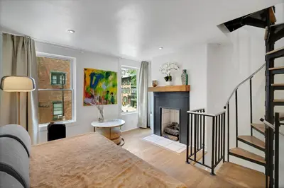 a living room with a staircase and a fireplace at The Twisty Nest on 17th in Philadelphia