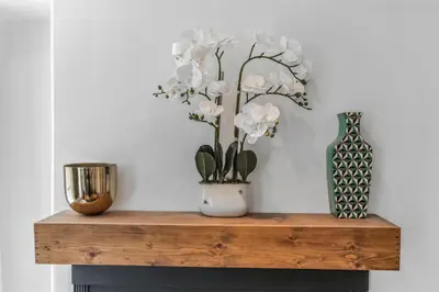 a wooden table with a vase and flowers on it at The Twisty Nest on 17th in Philadelphia