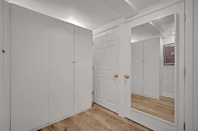 an empty hallway with white walls and a mirror at The Twisty Nest on 17th in Philadelphia