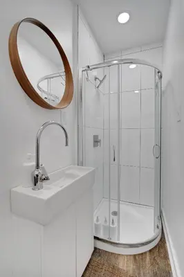 a bathroom with a shower and a sink and a mirror at The Twisty Nest on 17th in Philadelphia