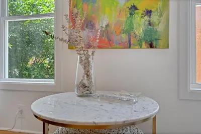 a table with a vase on it with a painting at The Twisty Nest on 17th in Philadelphia