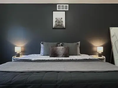 a bedroom with a large bed with a black wall at Pocolonial Charming 4BR Mountain Retreat in Albrightsville