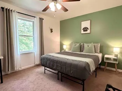 a bedroom with a bed with green walls and a window at Pocolonial Charming 4BR Mountain Retreat in Albrightsville