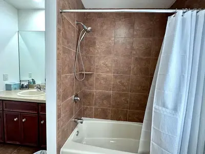 a bathroom with a shower and a tub and a sink at Pocolonial Charming 4BR Mountain Retreat in Albrightsville