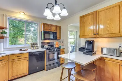 a kitchen with wooden cabinets and a counter top at Spacious Fanwood Home with Decks, Walk to Park!