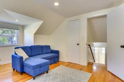a living room with a blue couch and a rug at Spacious Fanwood Home with Decks, Walk to Park!