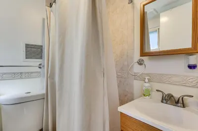 a bathroom with a shower curtain and a sink at Spacious Fanwood Home with Decks, Walk to Park!