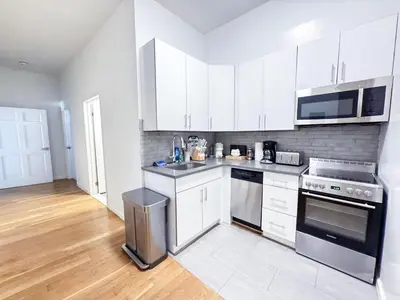 a kitchen with white cabinets and stainless steel appliances at Residence Heritage Giant 3 Bedroom in New York