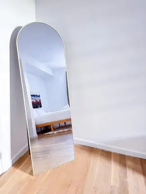 a mirror in the corner of a room with a couch at Residence Heritage Giant 3 Bedroom in New York