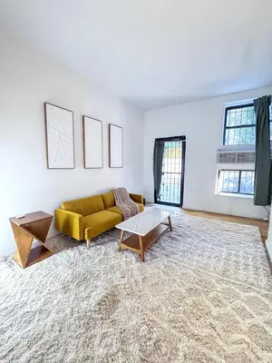 a living room with a yellow couch and a table at Residence Heritage Giant 3 Bedroom in New York