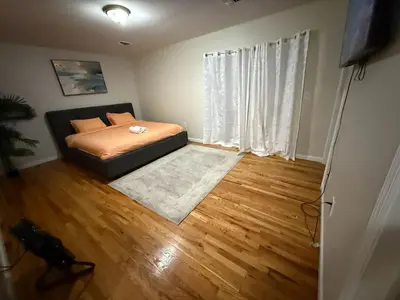 a bedroom with a bed and a wooden floor at Urban haven 3 Kings bedroom near EWRNYC DTW in Newark