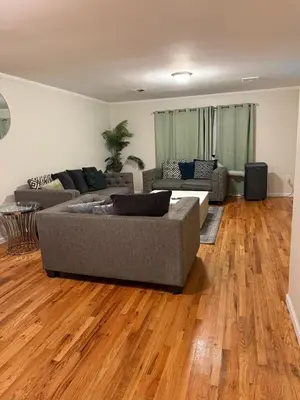 a living room with a couch and wooden floors at Urban haven 3 Kings bedroom near EWRNYC DTW in Newark