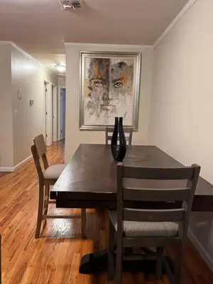 a dining room table with chairs and a vase on it at Urban haven 3 Kings bedroom near EWRNYC DTW in Newark