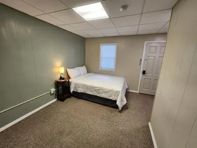 a small room with a bed and a window at Dunnstown Lodge in Lock Haven