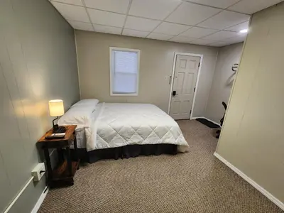 a bedroom with a bed and a table and a window at Dunnstown Lodge in Lock Haven