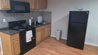 a kitchen with a black stove and a refrigerator at Work & Stay - NYC - EWR - Train Walk in Newark
