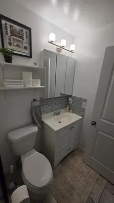 a bathroom with a white toilet and a sink at Work & Stay - NYC - EWR - Train Walk in Newark