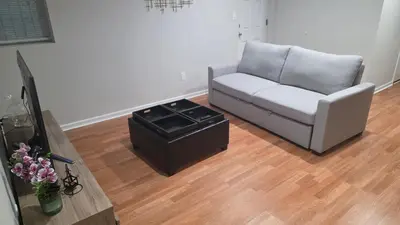 a living room with a couch and a table at Work & Stay - NYC - EWR - Train Walk in Newark
