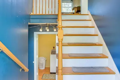 a staircase in a house with a blue wall at Hike, Ski and Explore Otisville Retreat with Yard! in Otisville