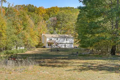 a house in the middle of a field with trees at Hike, Ski and Explore Otisville Retreat with Yard! in Otisville