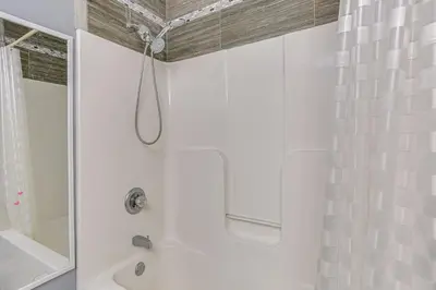 a white bathroom with a shower and a tub at Hike, Ski and Explore Otisville Retreat with Yard! in Otisville
