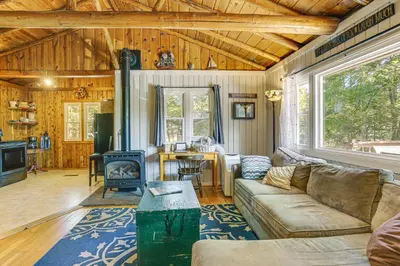 a living room with a couch and a stove at Boat, Hike and Fish Rustic Greenwood Retreat in Greentown
