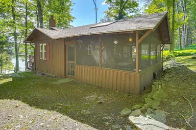 a small cabin in the woods with a large window at Boat, Hike and Fish Rustic Greenwood Retreat in Greentown