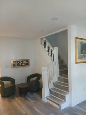 a staircase in a house with two chairs and a table at Labelle in Wilkes-Barre