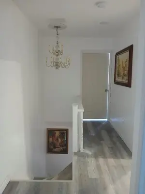 a white room with a chandelier and a hallway at Labelle in Wilkes-Barre