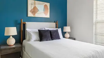a bedroom with a bed with blue walls and two lamps at Landing Spectacular 2BD Clubhouse Pool in King of Prussia