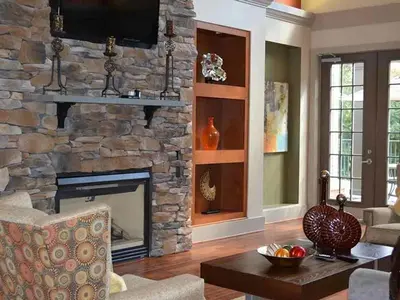 a living room with a stone fireplace with a television at Landing Spectacular 2BD Clubhouse Pool in King of Prussia