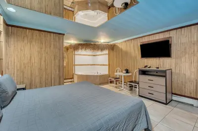 a bedroom with a bed and a flat screen tv at Bentley Motel in Linden